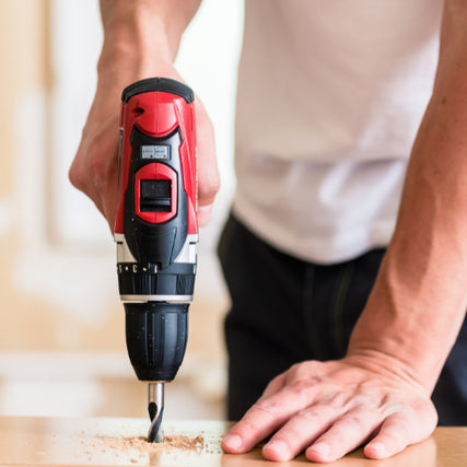 DIYA close-up of a red power drill being used.