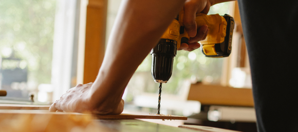 A close-up of a power drill being used.